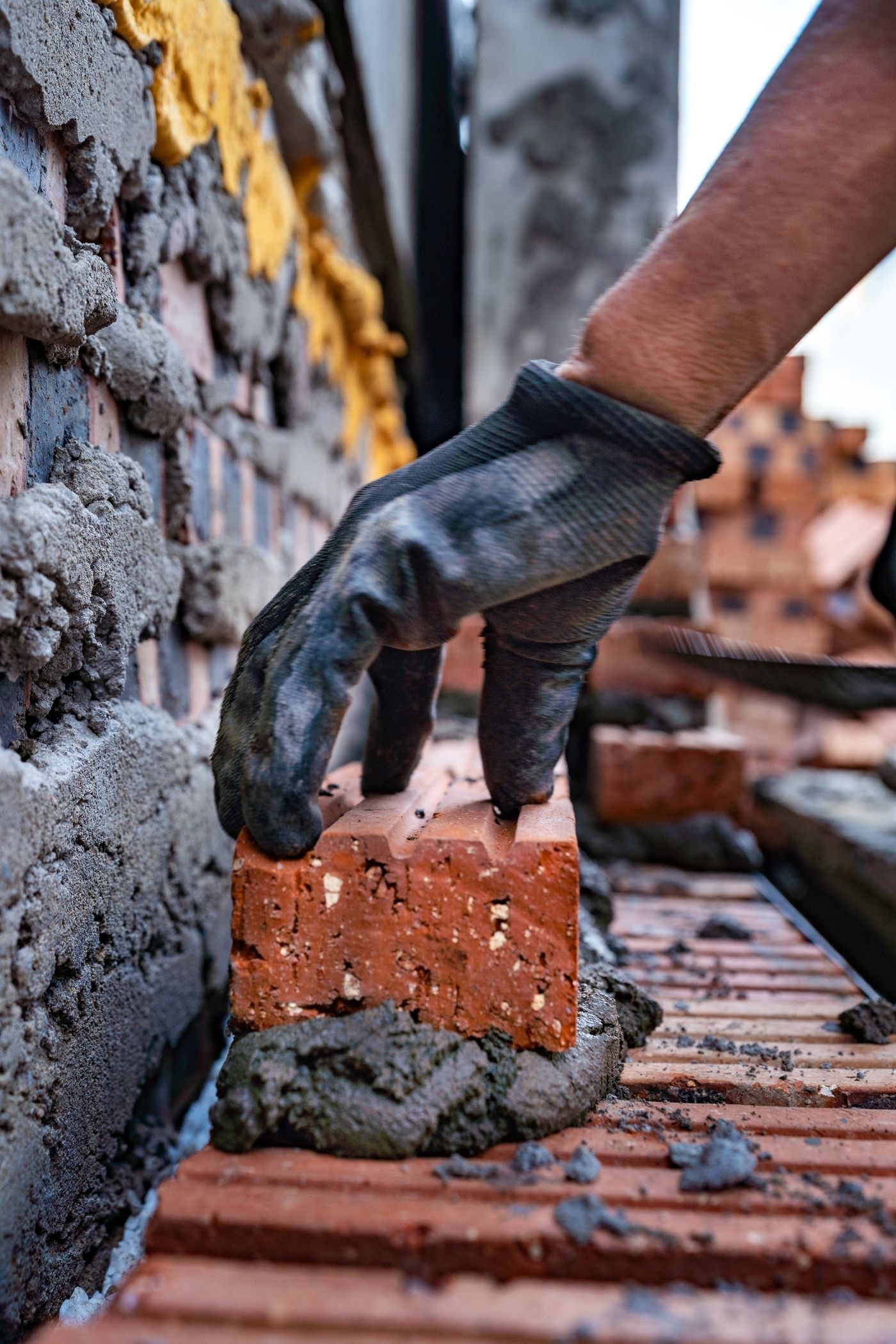 Mason laying brick on fresh mortar