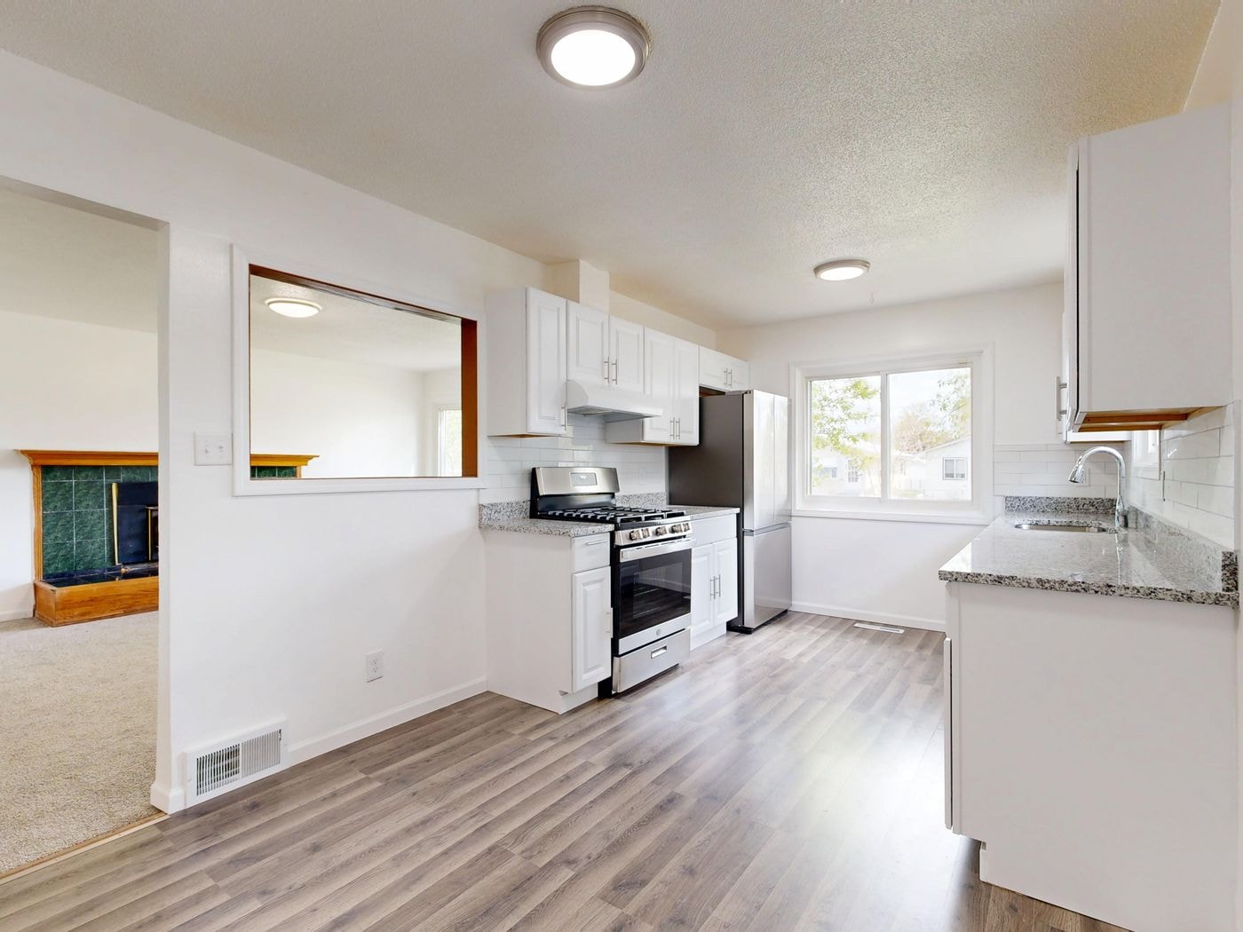 Newly remodeled kitchen with white cabinets and stone counters